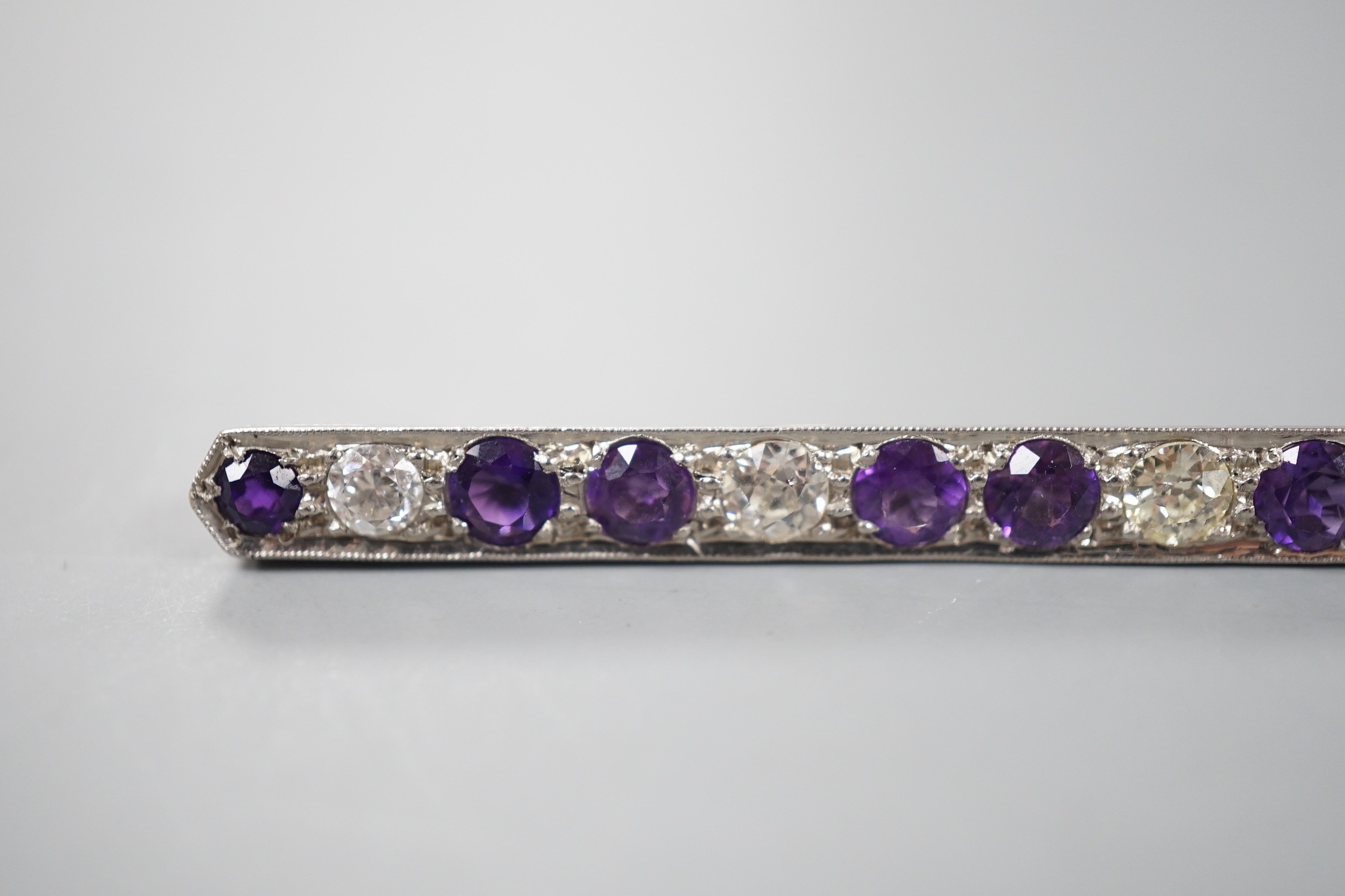 A mid 20th century white metal, amethyst and diamond set bar brooch, 57mm, gross weight 4.5 grams.